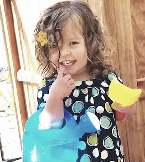 Child playing with a wattering can